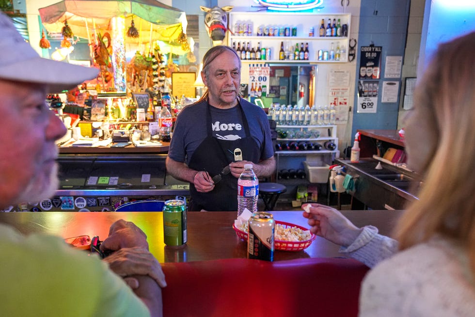 "Clutch," a bartender at the Carousel Lounge talks to Kristy Knight, right, and Neal Dambra, left, at the bar on Friday, February. 24, 2024 in Austin.